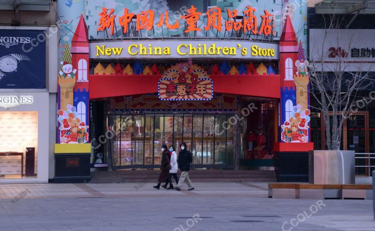 场景类：戴口罩的青年走过王府井新中国儿童商店