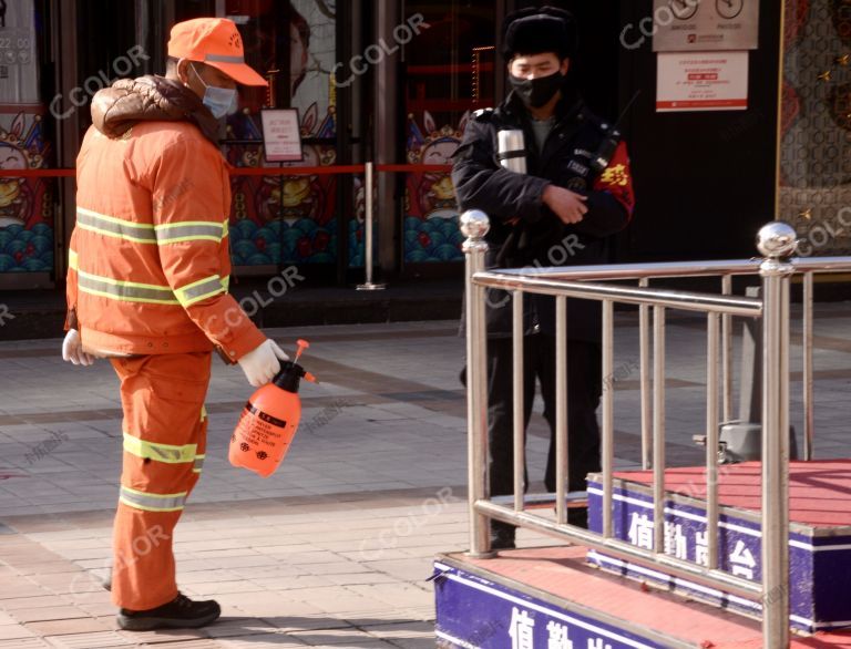 场景类：王府井大街戴口罩的保洁员对执勤岗站消毒 新冠防控
