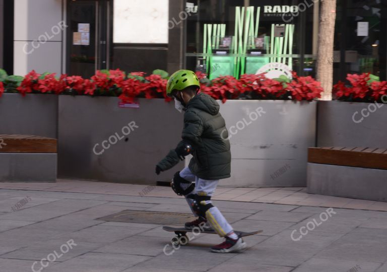 场景类：新冠防控期，戴口罩的小男孩在王府井大街玩滑板