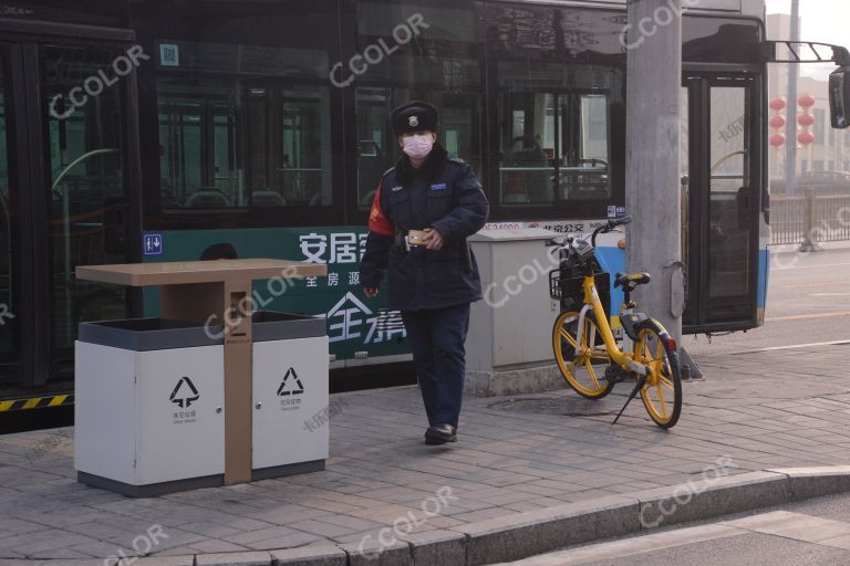 场景类：新冠疫情防控期，北京站西戴口罩的公交管理员