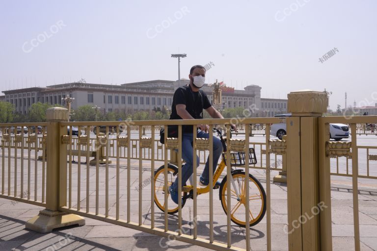 场景类：外国人，疫情防控期戴口罩的外国人骑车通过长安街