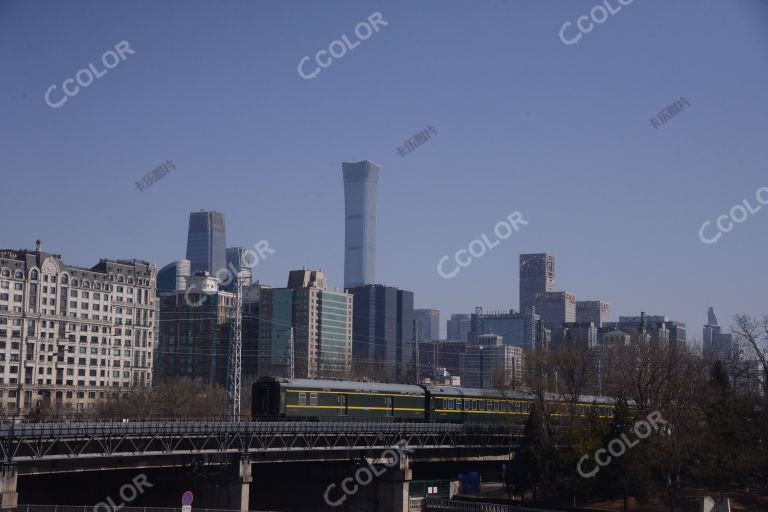 场景类：绿皮火车驶出北京站，背景为国贸商圈和中华世纪尊