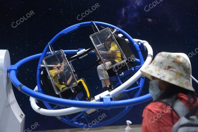 中国科技馆航天成就展，游客在“三维滚环”中体验航天员训练