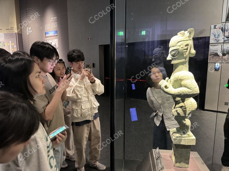游客拍摄青铜着裙立人像